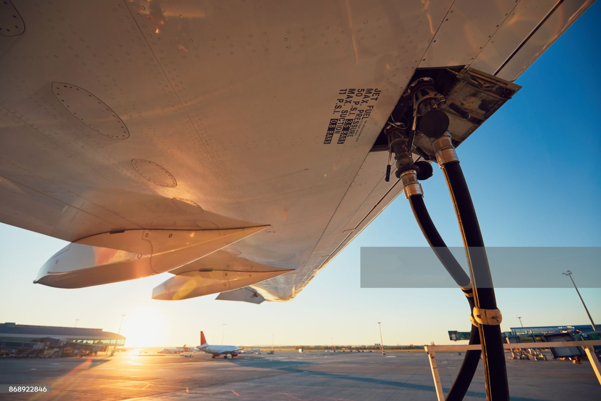 Amazing sunset at the airport. Refueling of the airplane before flight.